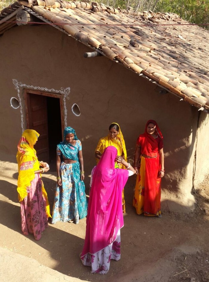women standing near village hut